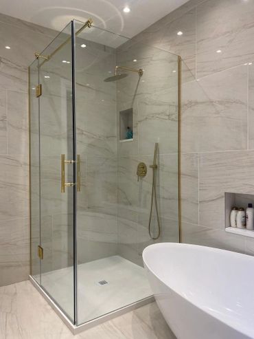 Modern bathroom with glass shower enclosure and freestanding bathtub.