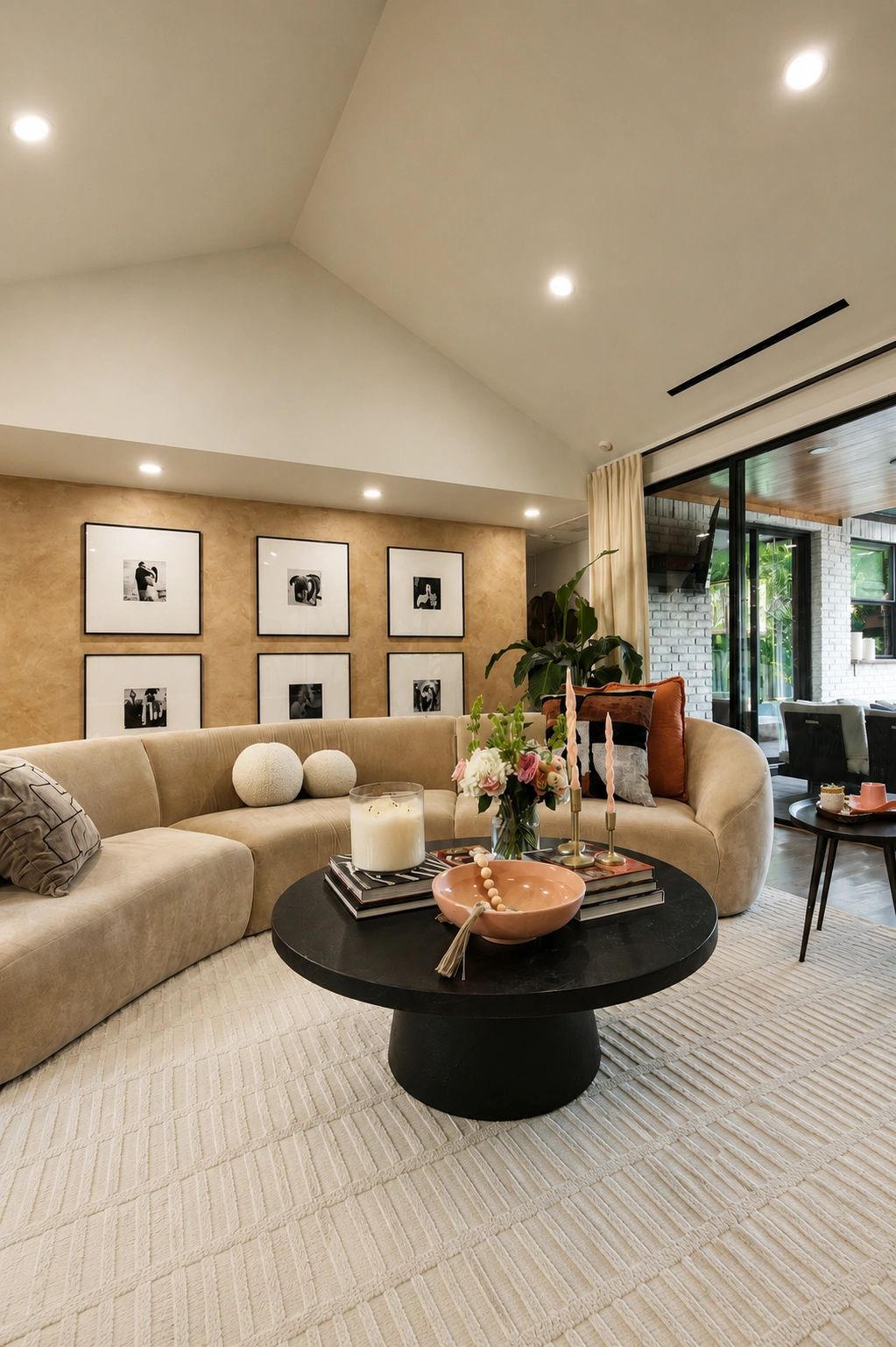 Modern living room with a curved beige sofa and black coffee table.