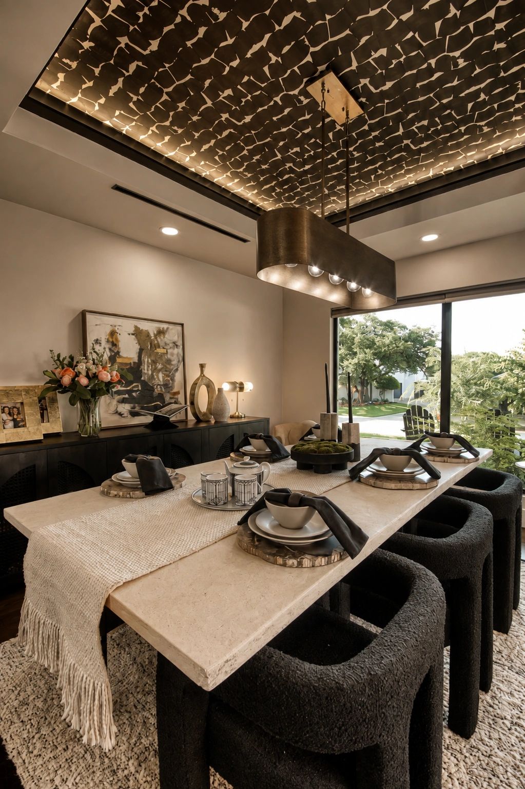 Modern dining room with textured black chairs and artistic ceiling.