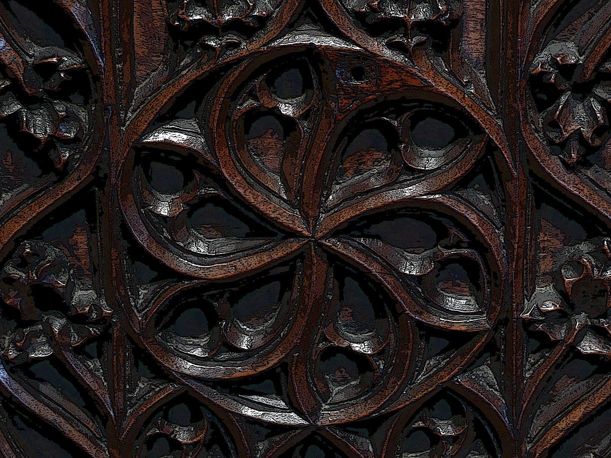 Intricate dark wooden carving with floral motifs.