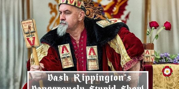 Man dressed as a king adorned with mousetraps, holding a mousetrap scepter.