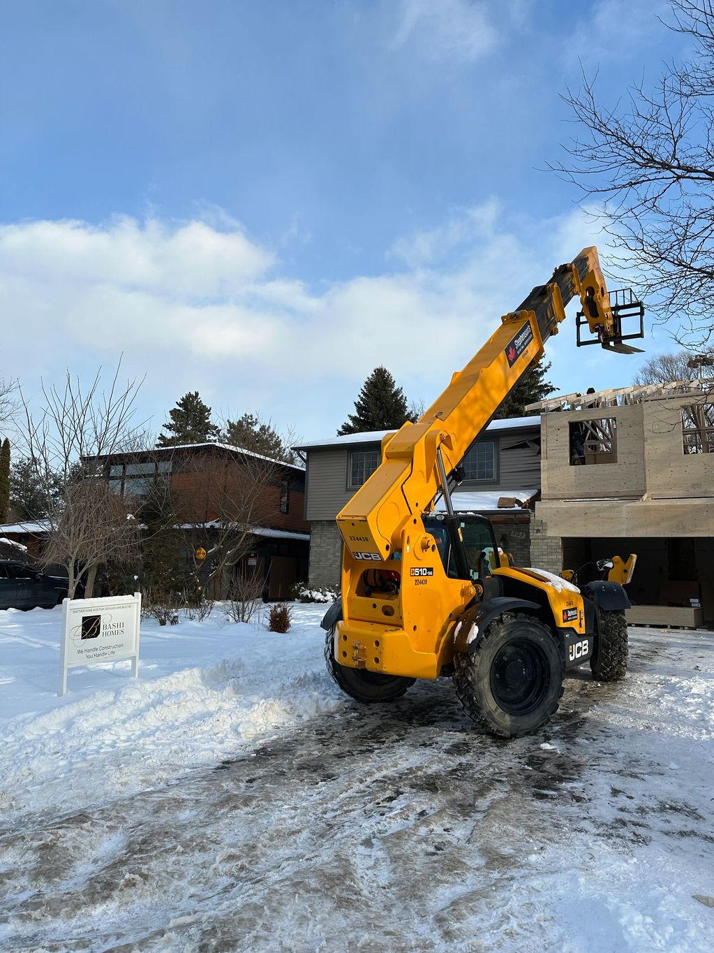 Our team utilized a telehandler to safely lift and position roof trusses on this Ancaster home addit