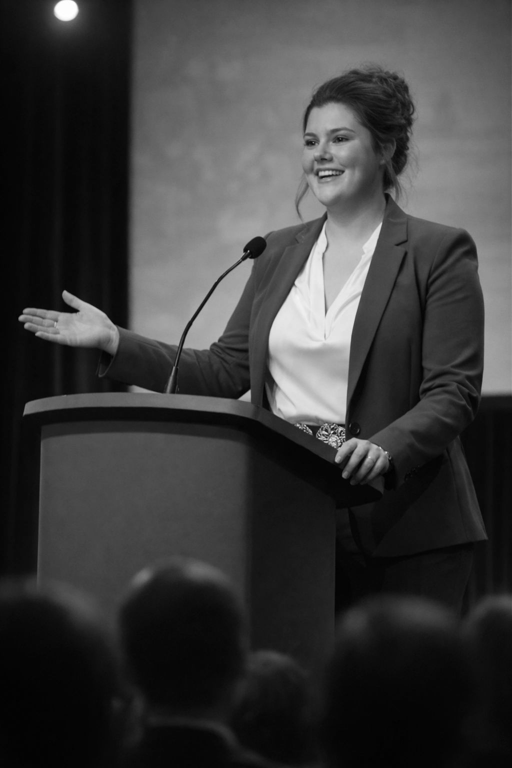 A woman confidently speaks at a podium during a formal event.
