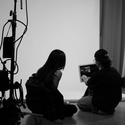 Two people reviewing photos on a laptop in a photography studio.
