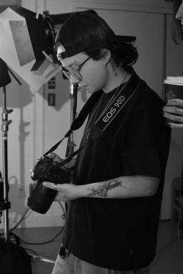 Person with a camera reviewing photos in a studio setting.