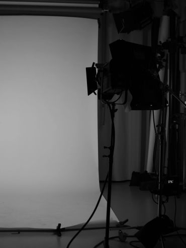 Black and white photo of a photography studio setup with lights and backdrop.