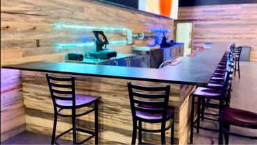 A commercial bar/restaurant countertop made of brushed black granite.