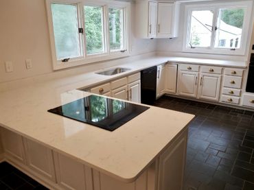 A kitchen with white cabinets and white quartz countertops