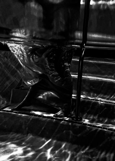 Black and white image of person underwater. 