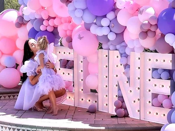 Toddler dressed as a princess being kissed by her mother