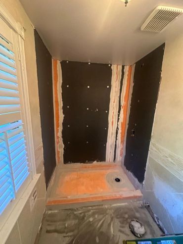 Shower area under renovation with waterproofing applied.