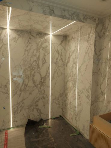 Marble walls with integrated vertical LED lighting strips.