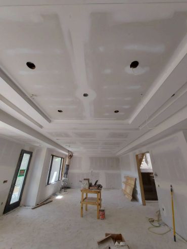 Room under construction with drywall installation.