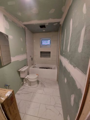 Bathroom under construction with unfinished walls and installed fixtures.