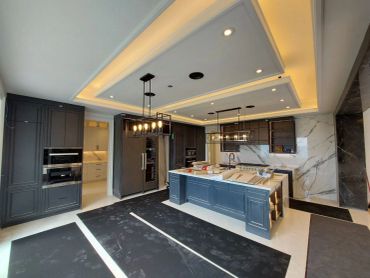 Modern kitchen with marble accents and blue cabinetry.