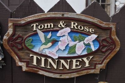 Rustic wooden sign reading Tom &amp; Rose Tinney.