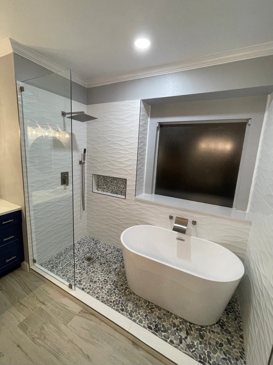 Modern bathroom with freestanding tub and walk-in shower with pebble floor tiles.