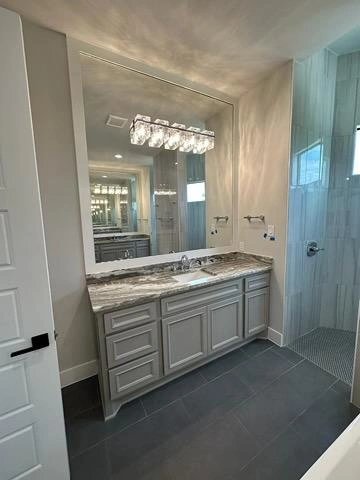 Modern bathroom vanity with marble countertop and large mirror.