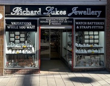 Front view of Richard Lukes Jewellery shop with display windows and services advertised.