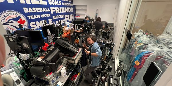 Crowded workspace with film equipment and people working.