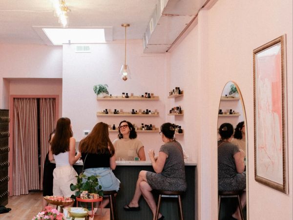 A cozy beauty shop with clients and a staff behind the counter.