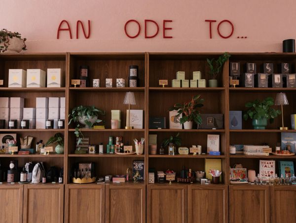 Decorative shelves with plants and products under text 'AN ODE TO...'.