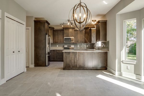 Modern kitchen with dark wood cabinets and tiled floor.
