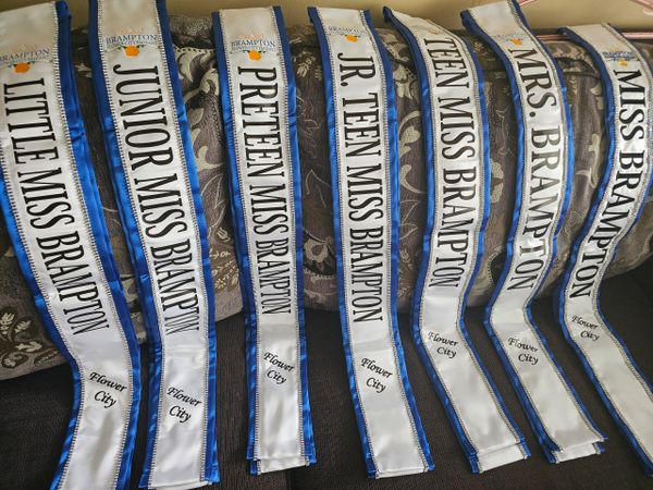 Sashes from various Brampton beauty pageant titles arranged on a couch.