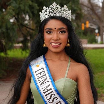 Young woman crowned Teen Miss wearing a sash and tiara.