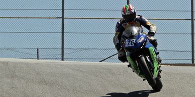 Motorcyclist jumping over a hill on a race track.