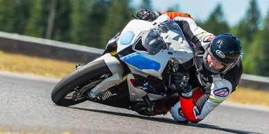 Motorcyclist leaning into a turn on a racetrack.