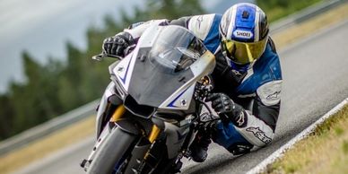 Motorcyclist leaning into a turn on a race track.
