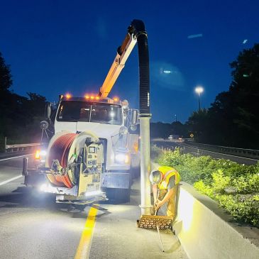 vacuum truck cleaning catch basin on roadway