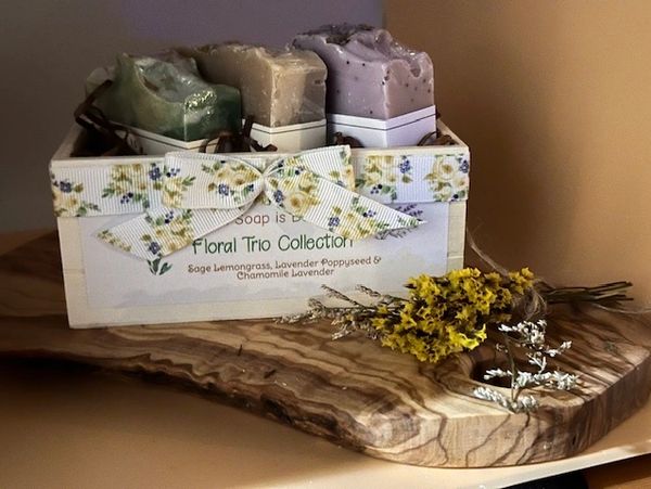 Floral Trio Collection of handmade soap displayed in a wooden gift box decorated with dried flowers and a floral ribbon. Natural plant based ingredients are used in our vegan soap. We strive to provide cruelty free soap as no animal testing is done on any of our products.