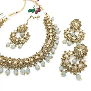 Ornate gold and pearl traditional jewelry set with necklace and earrings.