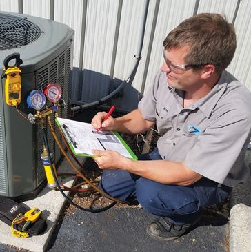 Technician inspecting HVAC system outdoors.