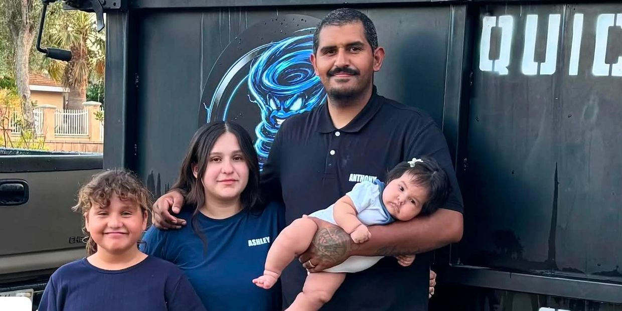 Family posing with a baby in father's arms.