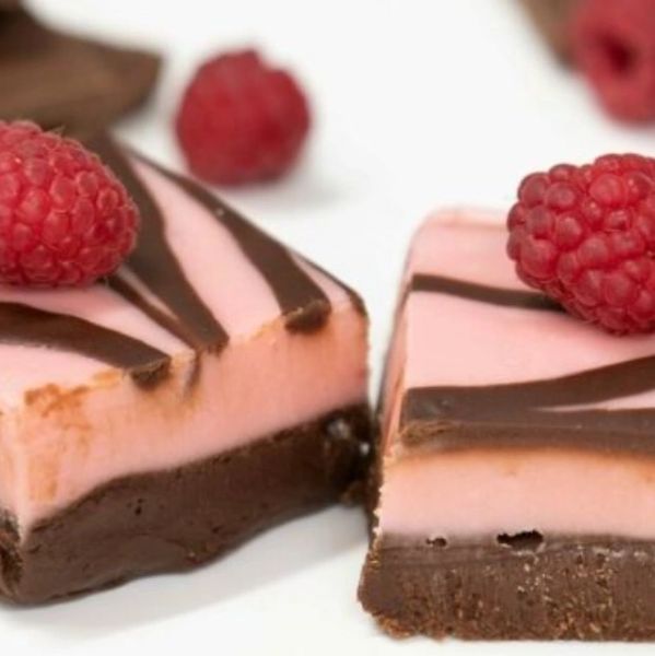 Two chocolate and pink raspberry dessert bars topped with fresh raspberries.