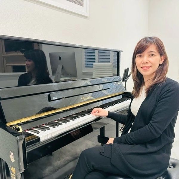 A woman sitting beside piano