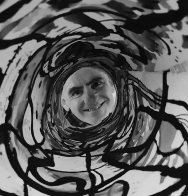 Man smiling through a swirling abstract tunnel.