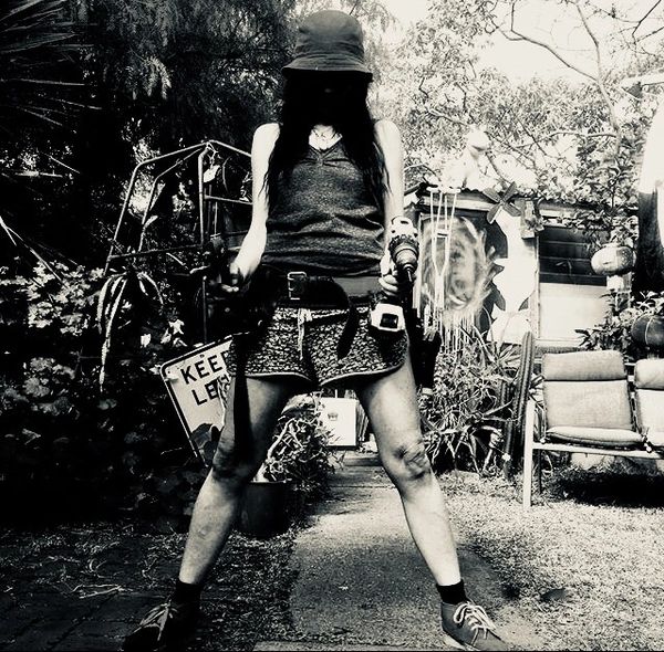 Person in hat holding tools with wide stance.