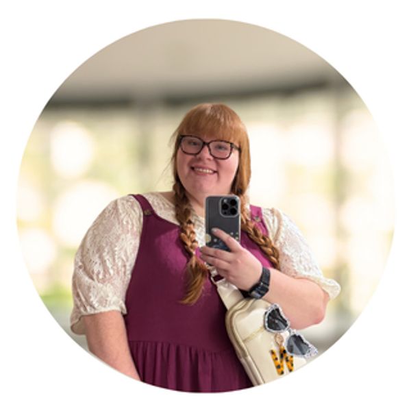 Woman with glasses and braids taking a selfie.