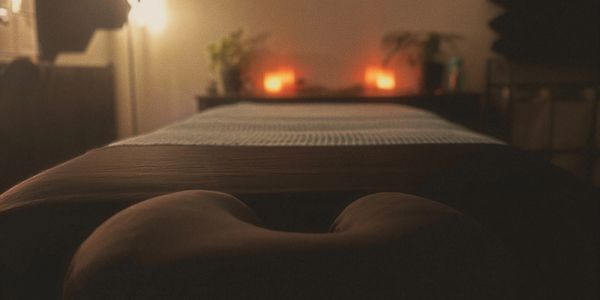 A dimly lit massage table with candles glowing softly in the background.