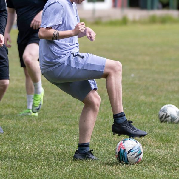 Groups of young adults developing football skills together 