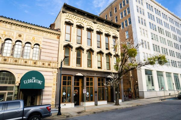 Historic buildings line a quiet city street on a sunny day.