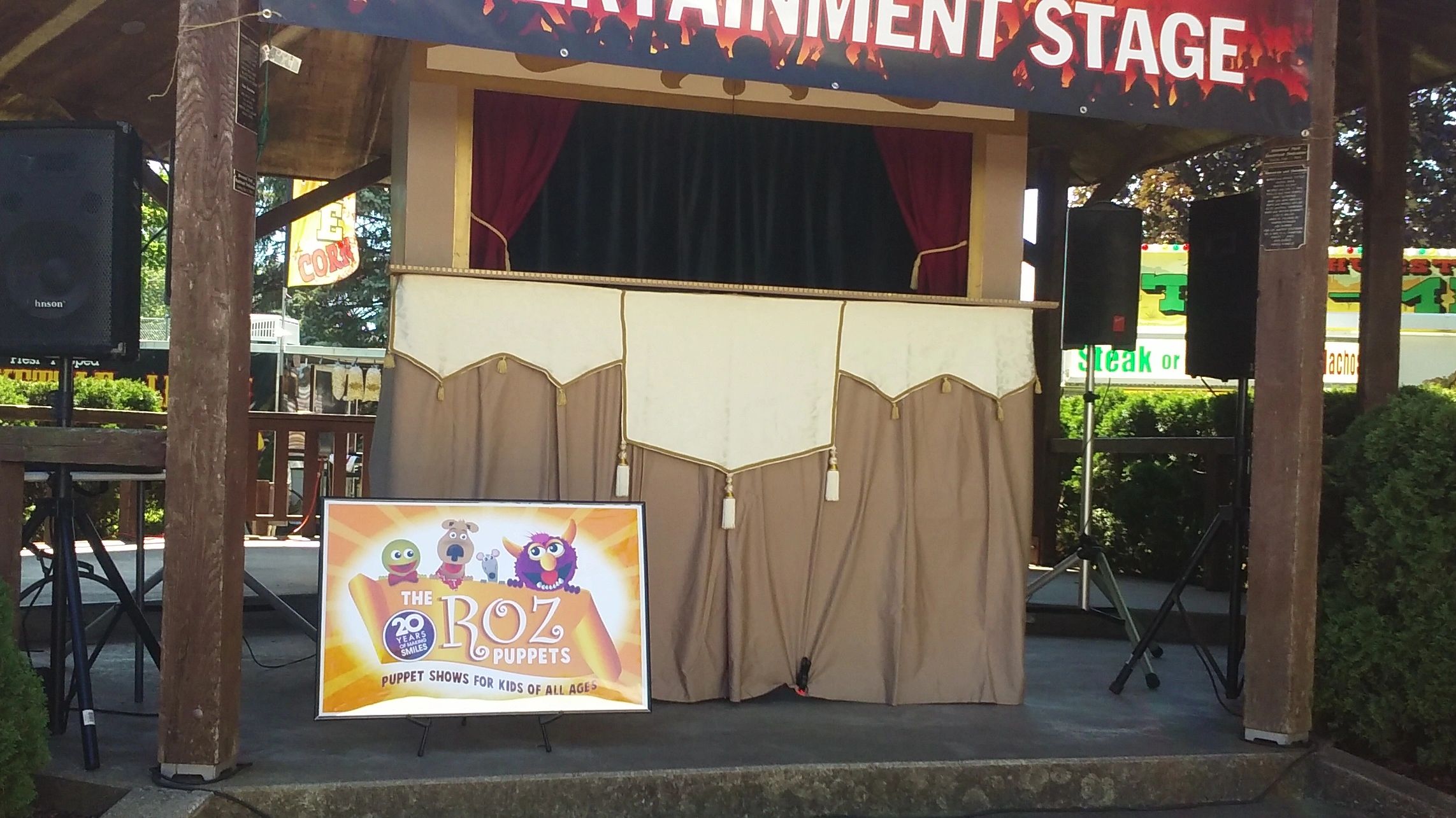 Puppet show stage under a gazebo at a summer festival.