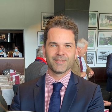 Man in suit smiling at a formal event.