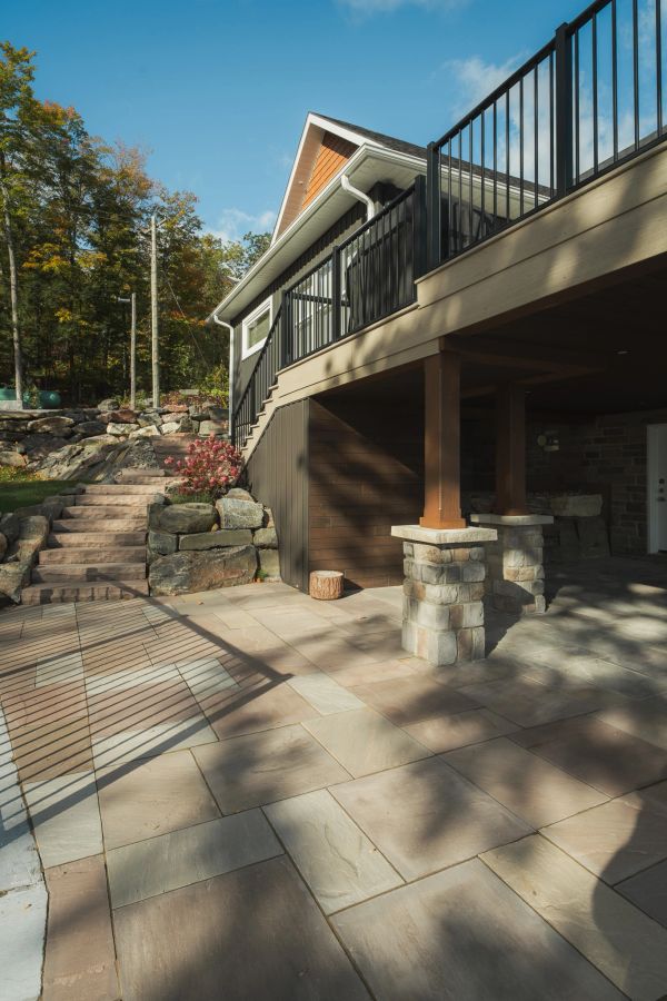 Modern house patio with stone pillars and tiled floor.