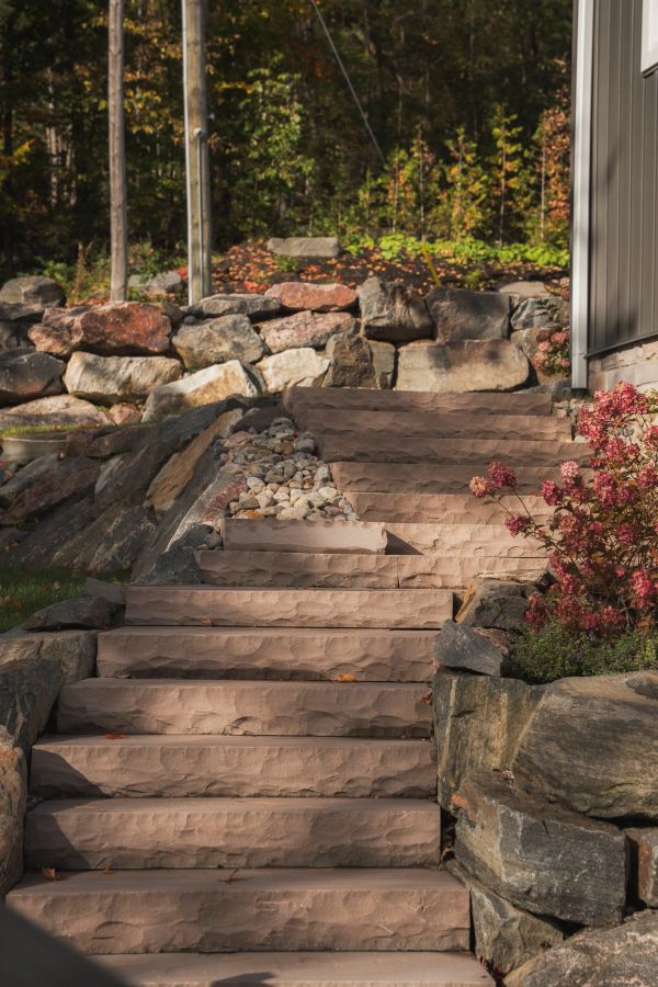 Stone stairs with plants and rocks on the side.