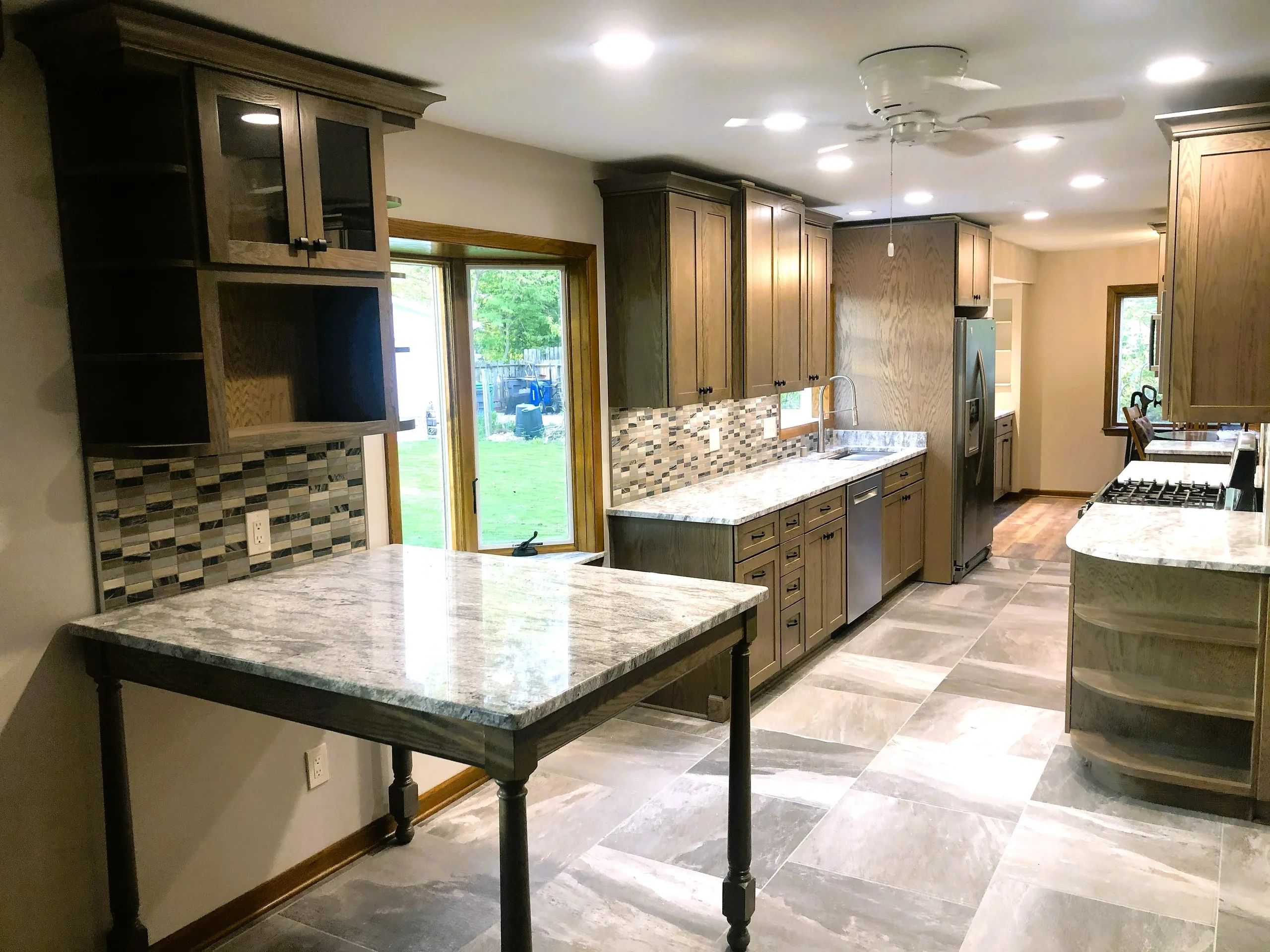 Modern kitchen with wooden cabinets and granite countertops, tile backsplash, and Slate tile floor,